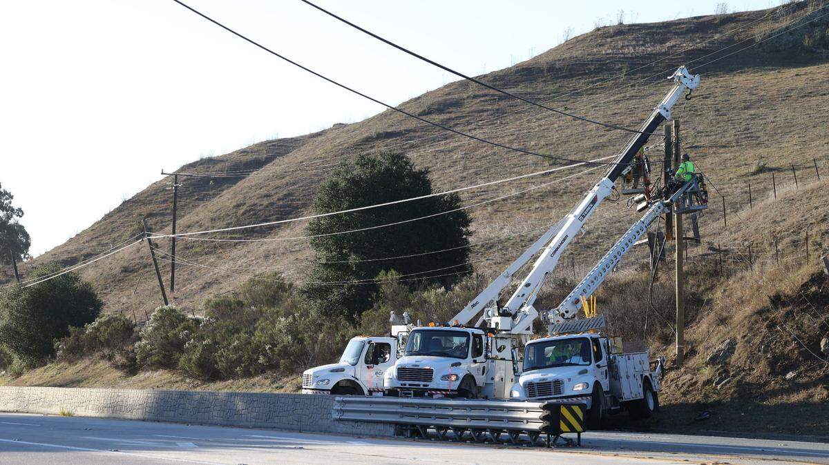 Utility crews work to repair lines across Highway 1 at Stenner Creek Road in San Luis Obispo on Sunday, Oct. 23, 2022.