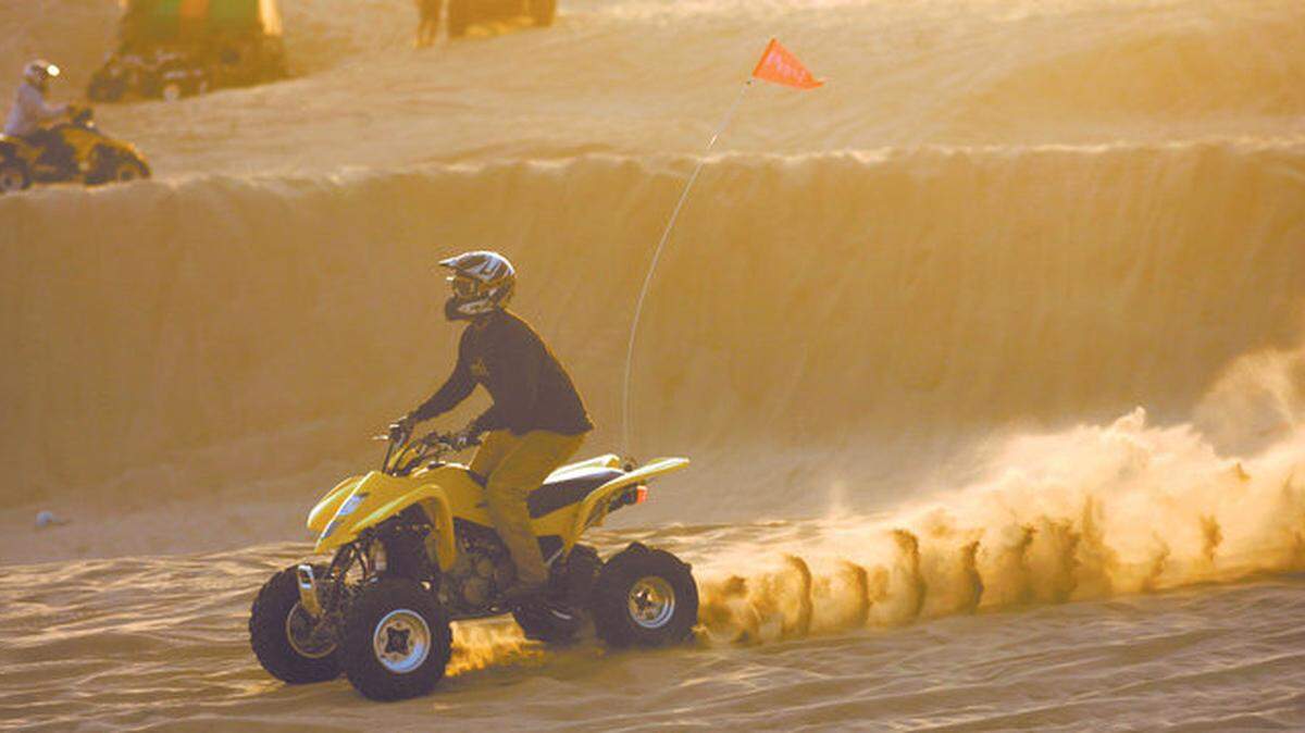An ATV rider kicks up sand at the Oceano Dunes State Vehicular Recreation Area.