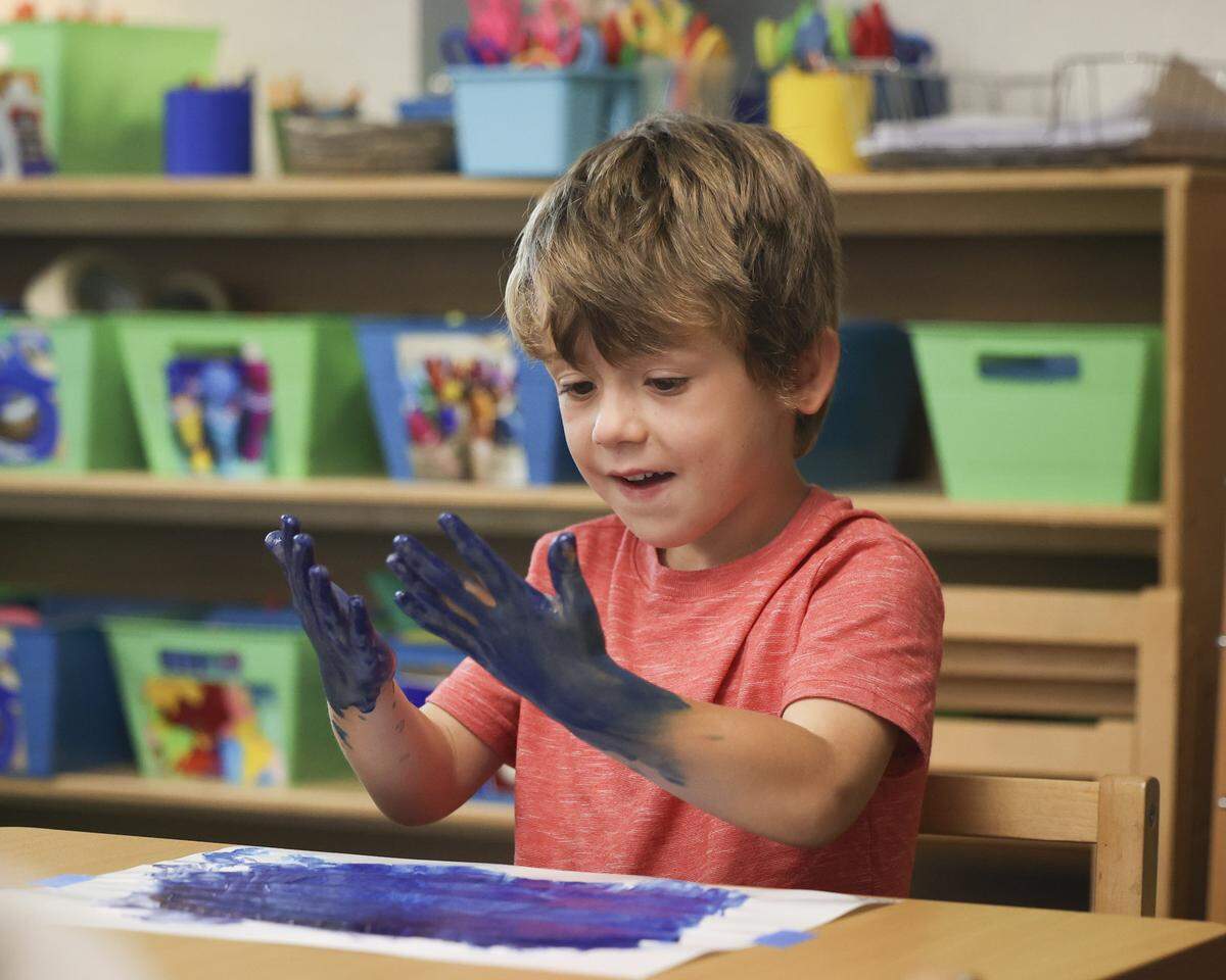 Teacher Fiona Lloyd-Moffett leads her transitional kindergarten students in play-based lessons that teach academic and social skills tailored to their age. Jack fingerpaints on Sept. 18, 2025. The activity engaged motor skills, mixing two colors to make a third, and learning how to follow instructions and clean up after a project.