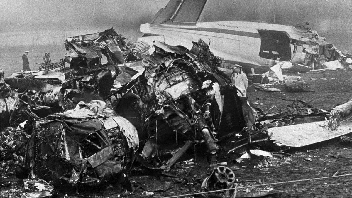 Investigators survey the scene after the Cal Poly football team’s charter plane crashed on takeoff from an airport near Toledo, Ohio, on Oct. 29, 1960. Sixteen Mustang football players, the student manager, a member of the Mustang Booster Club, and four others died in the crash.