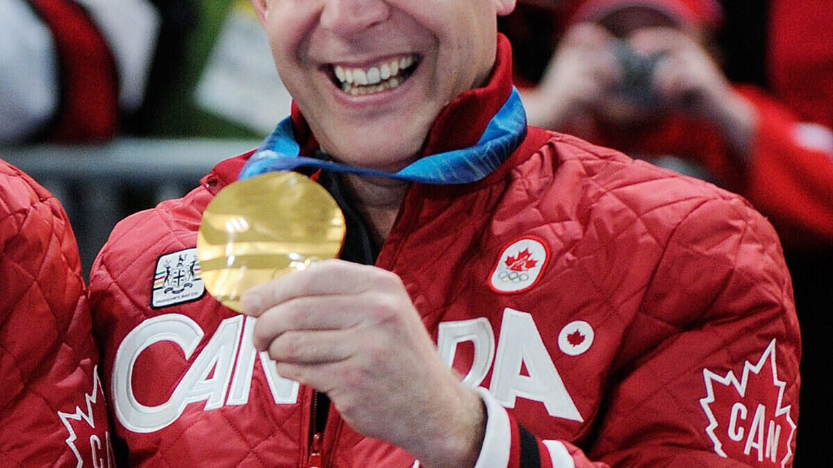 Canada's skip, Kevin Martin, holds up his gold medal. (Ric Ernst/Canwest News Service/MCT)