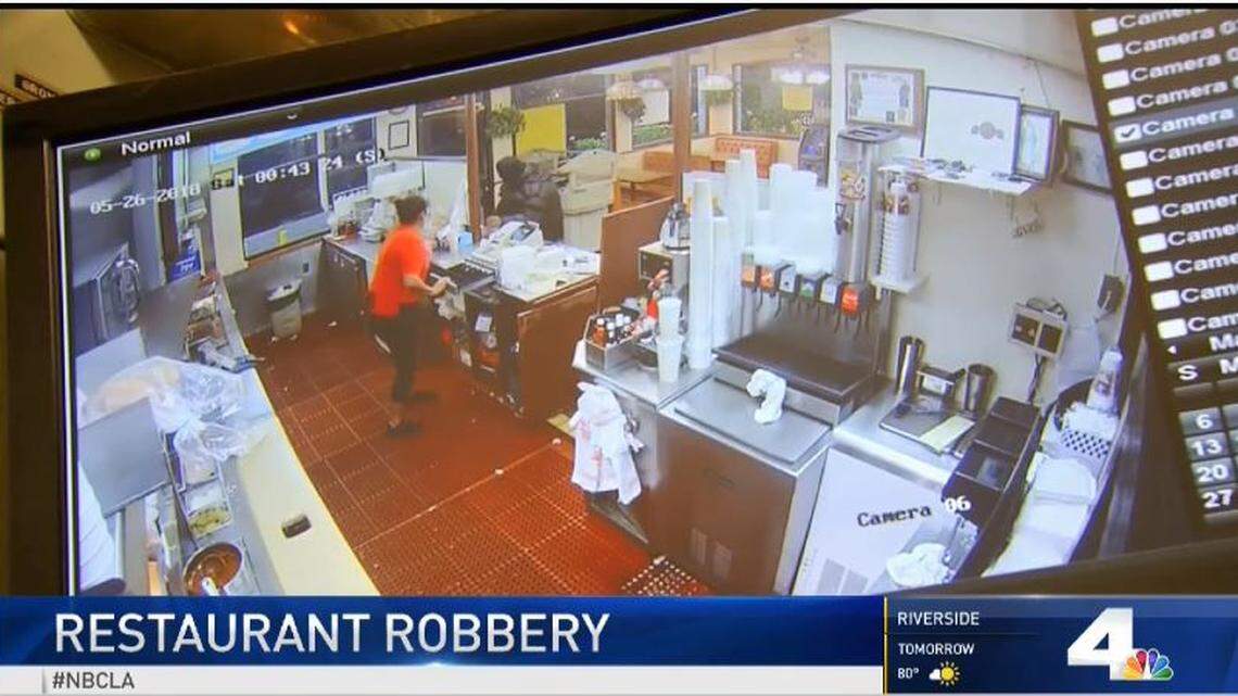 Surveillance footage from a Cozy Corner restaurant in Santa Ana, California, showing a robbery suspect at the restaurant's counter right before shots come through the drive-thru window.