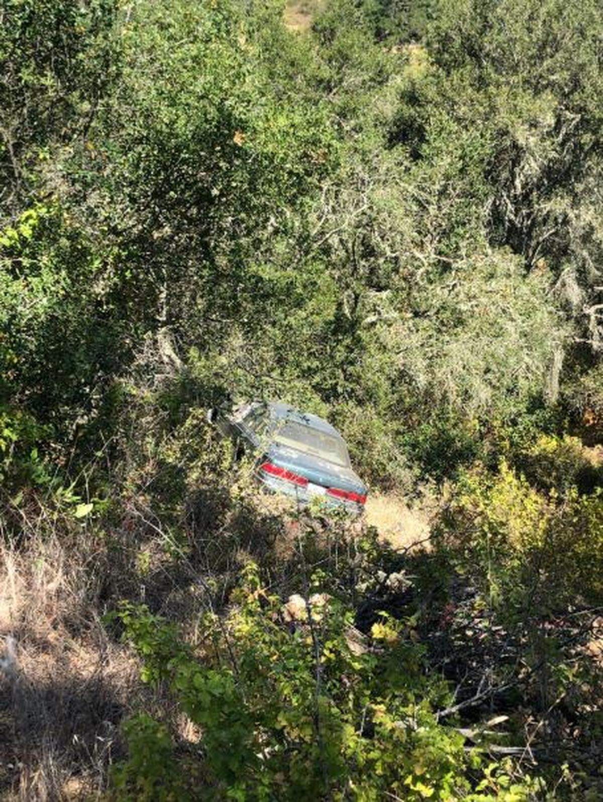 Emergency responders worked Sunday to free a person trapped in a car that plunged 50 feet down an embankment in Atascadero.