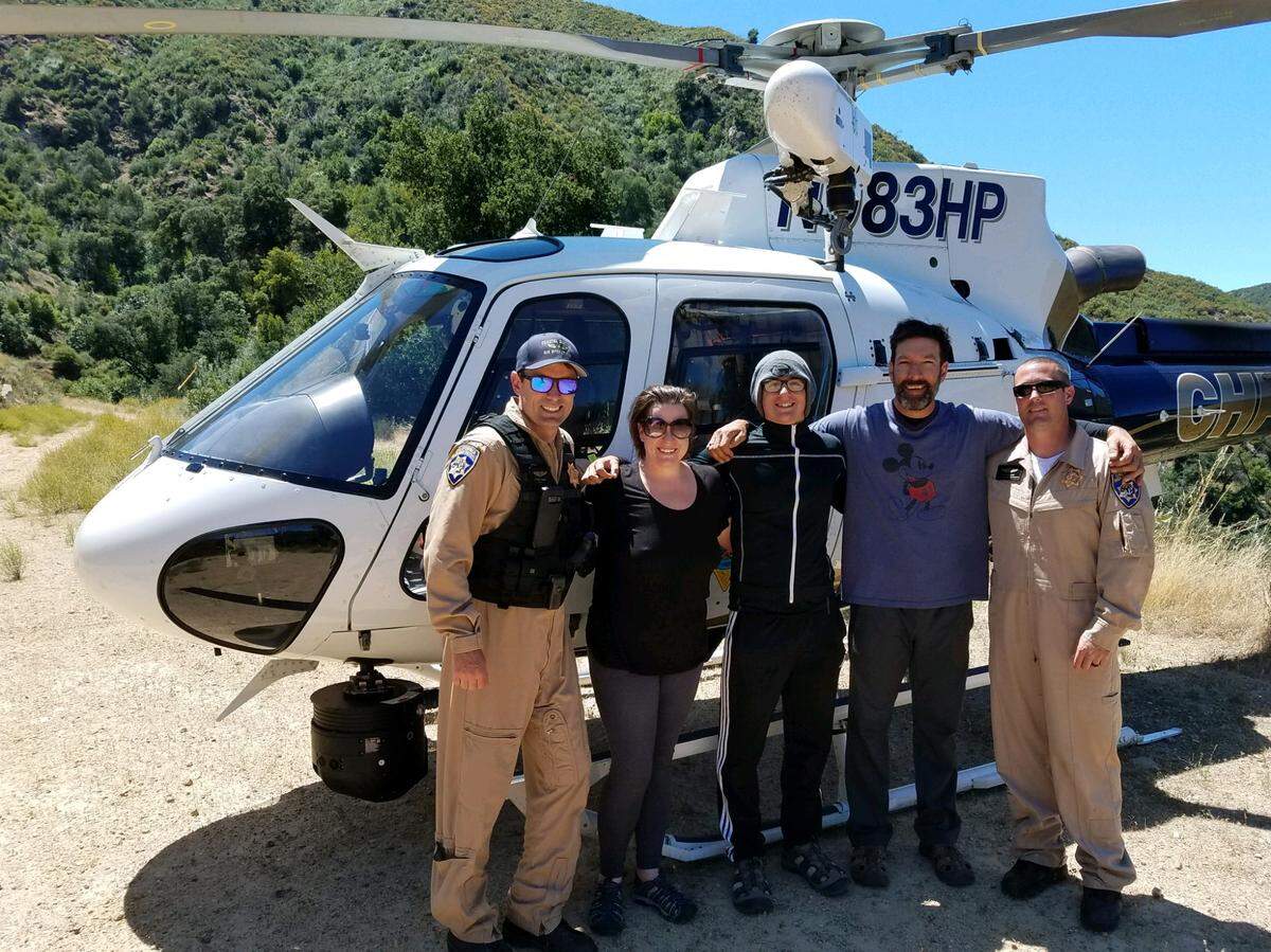 A CHP helicopter rescued the stranded local group. Officials are flanked by Krystal Ramirez, Hunter Whitson and Curtis Whitson (left to right in the middle).