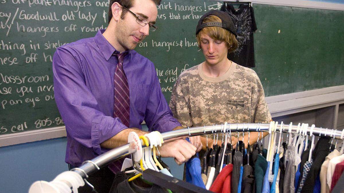Pacific Beach social science teacher Jeff Aranguena and Dillion Limpangug work on the hanger locks as the students work on setting up "Outreach Apparel"  a teen closet offering free clothing for teens in the school district.
David Middlecamp
3-15-2013