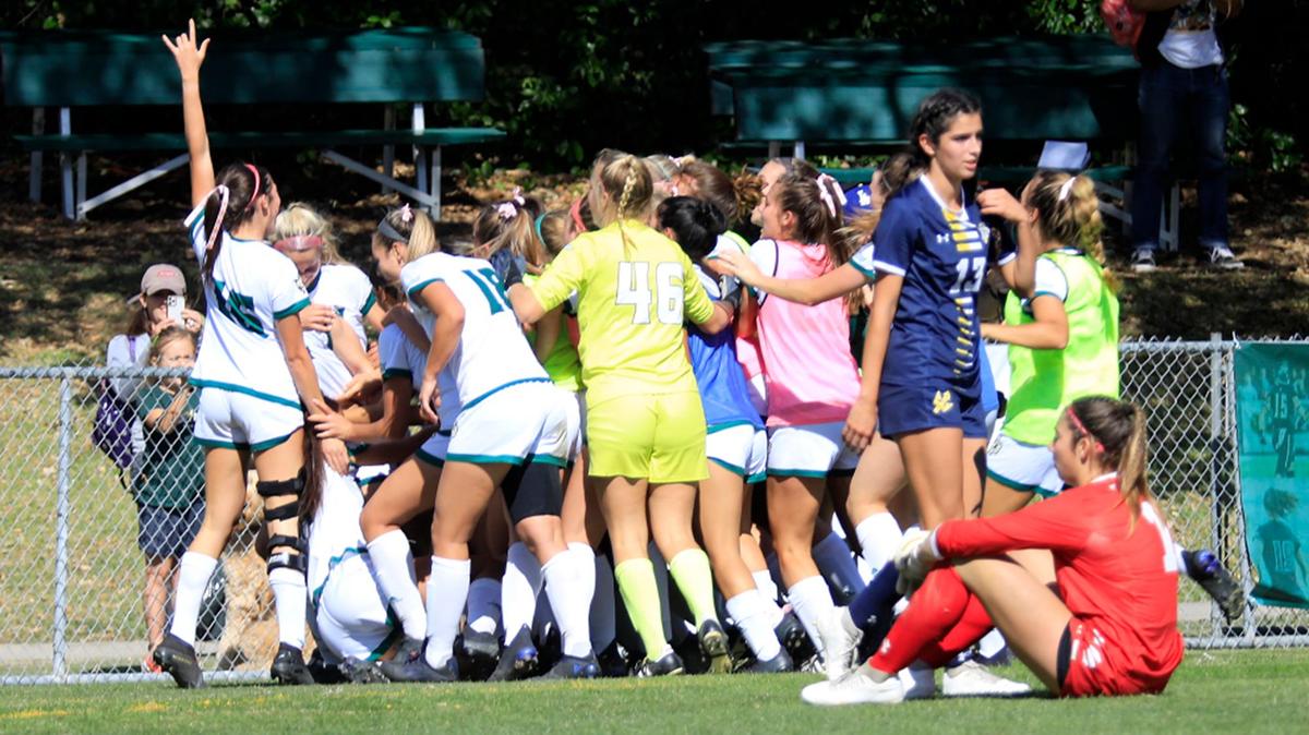 The Cal Poly Mustangs women soccer team celebrates after scoring the winning goal against the UC San Diego Tritons in overtime at Alex G. Spanos stadium in San Luis Obispo, Sunday, Oct. 17, 2021. Triton goalkeeper Grace Tylor (1) and Kate Hottinger (13) watch the celebration.