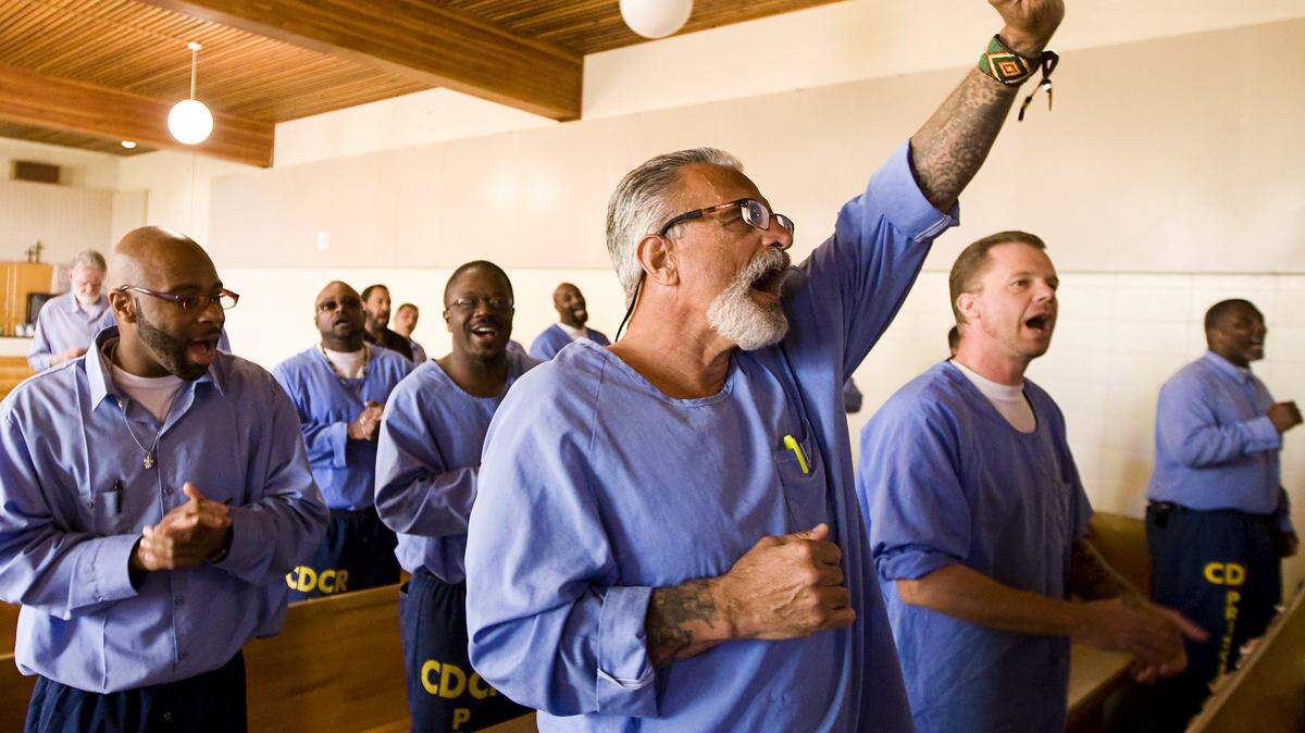 Robert Morales, center, John Sims, right, and several other inmates sing along during a service, made possible with the funding from Serving California, in the chapel at the California Men's Colony.
Photo by Joe Johnston 02-12-14