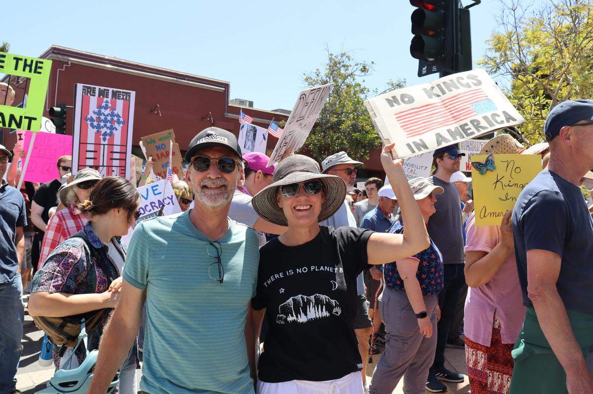 Rick Hirsch, left, and Angie Berlin join thousands of others in San Luis Obispo, California, for No Kings Day to protest executive overreach by the Trump administration on the President’s birthday.