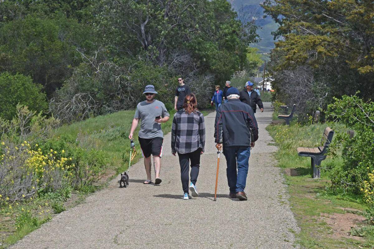 People enjoying a springtime stroll at Lake Los Carneros in Goleta.