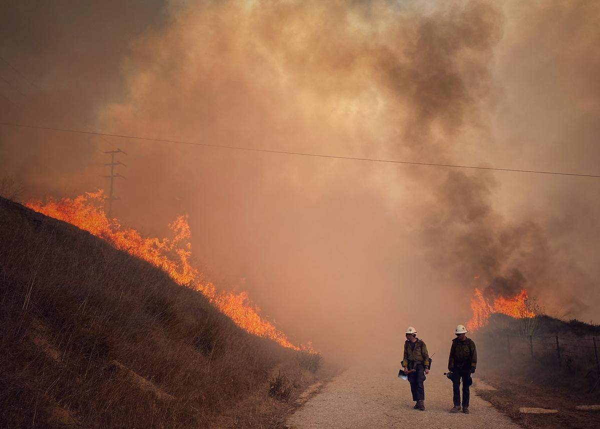 Santa Barbara County Fire Department hand crew members burn off pockets of grass along northbound Highway 101 north of Arroyo Hondo Canyon. The Alisal Fire had burned 14,500 acres as of Wednesday, Oct. 13, 2021.