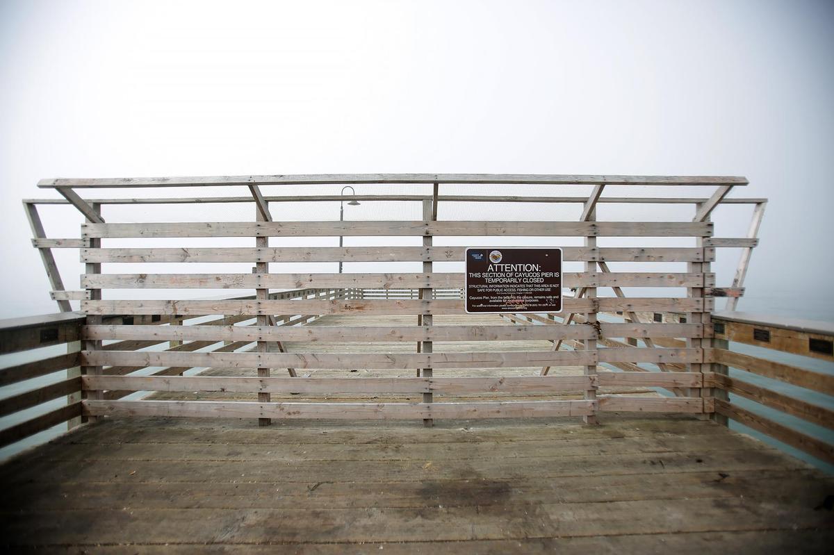 The end of the Cayucos Pier was damaged in a Feb. 20, 2024, storm that knocked loose multiple pilings. A sign and barrier close off the area on Saturday, May 31, 2025.