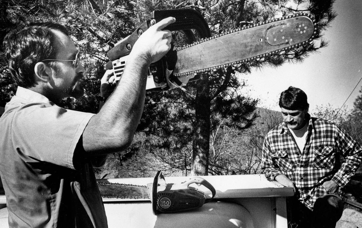 Forest Service Officer Doug Aversano checks spark arrester on Jeff Cattaneo’s chainsaw before issuing permit to cut firewood.