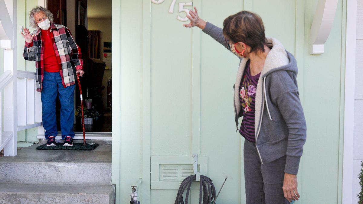 SLO Village volunteer Nicki Edwards waves goodbye after delivering groceries to Peggy Fabricius.