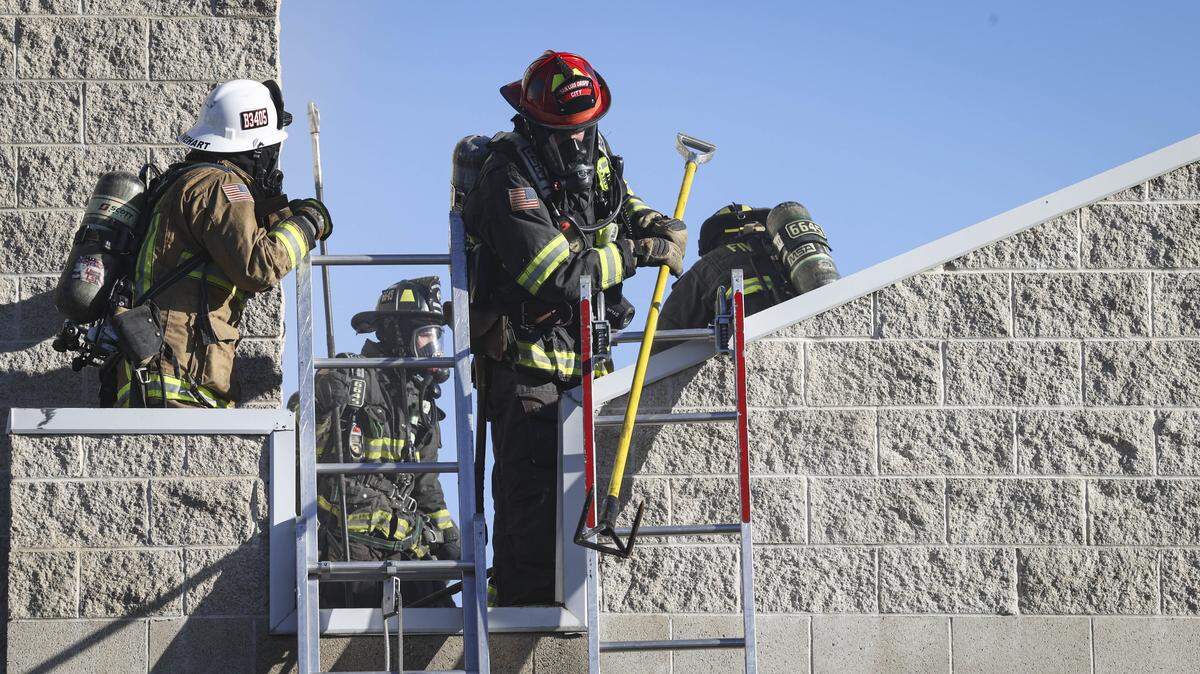 Firefighters work on the roof of the former Tribune building on South Higuera, currently the offices of E/ S/ Aero on Jan. 12, 2026. Smoke was ventelated out of the structure with a cut in the tin roof.