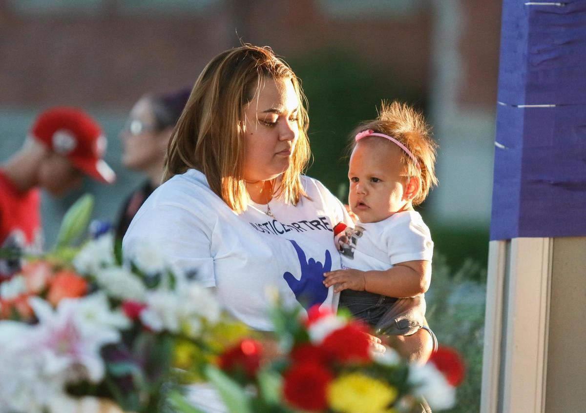 Trevon Perry’s sister, Caryssa Esquivel, holds his daughter at a community vigil for her brother in Downtown City Park in Paso Robles.