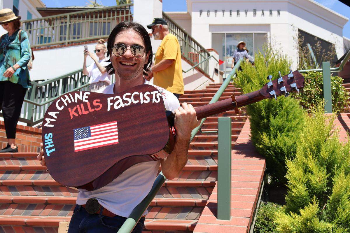 Ricky Stewart, a local musical artist from Oceano, attended the “No Kings” protest against the Trump administration in San Luis Obispo on June 14, 2025, with a guitar he painted with the words “This machine kills fascists.”