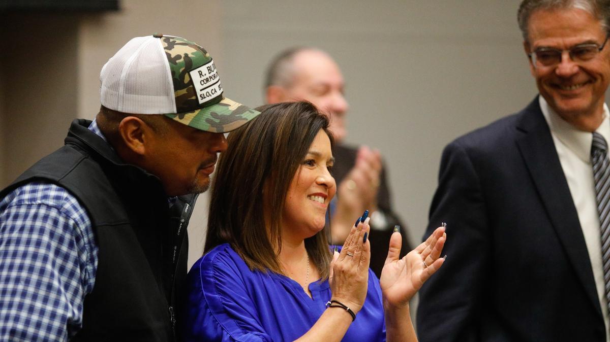 Maria Garcia gets a hug from fiancé Gilbert Ruelas as councilman Fred Strong applauds in background and Mayor Steve Martin smiles. Two Paso Robles City Council members and the mayor were sworn in on Tuesday: incumbent Mayor Steve Martin, incumbent Councilman John Hamon and new Councilwoman Maria Garcia. She is the first woman on the council in 34 years. 12-03-2018 David Middlecamp