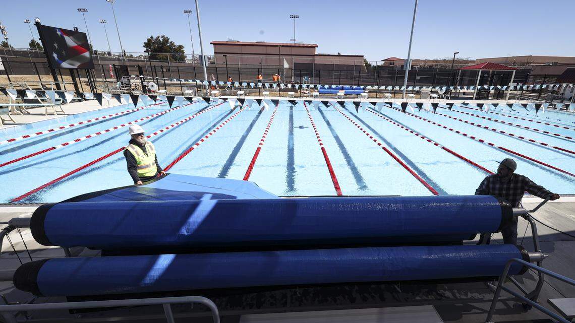 Dan Wells, left and Edgardo Barragan reel in protective covers. The eagerly anticipated aquatic center at Paso Robles High School was undergoing final finish work on March 5, 2026, the day before dedication.