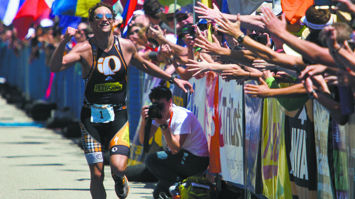 Jesse Thomas celebrates his 2012 win in the Wildflower Triathlon Longcourse championship with fans at the finish line.