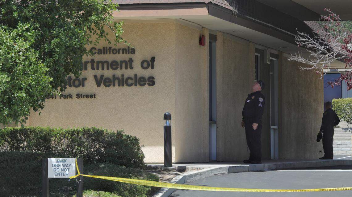 A California Highway Patrol officer examines the perimeter of the DMV office at 841 Park St. in Paso Robles following an early-morning shooting that wounded a sheriff’s deputy outside the police station and the discovery of a man fatally shot in the head north of the Amtrak station. Investigators believe the incidents are related. 