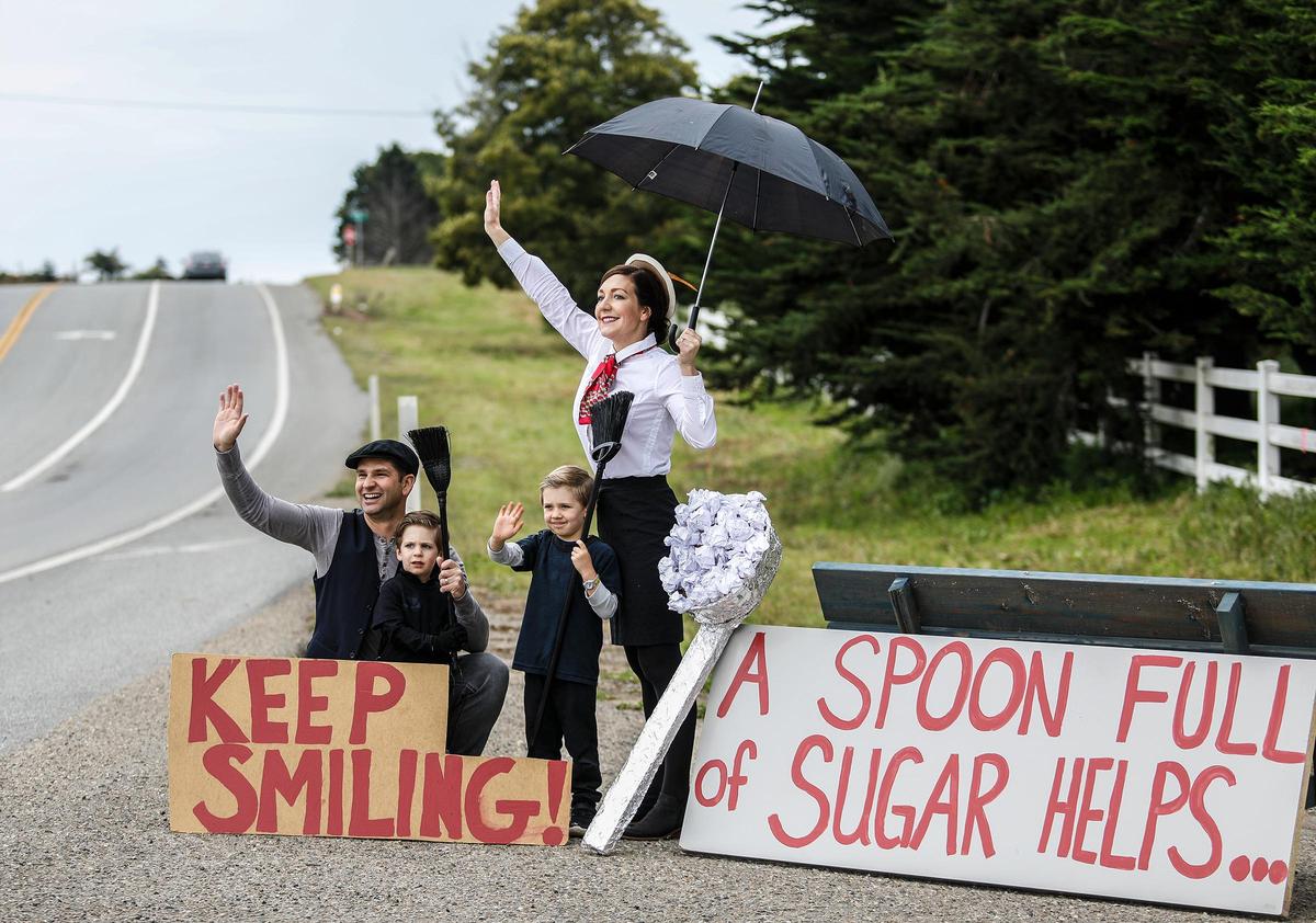 Casandra Cox, her husband Scott and sons Ryan, 2 (in Scott’s lap), and David, 5, dress up every day to wave at cars passing their Arroyo Grande home on Highway 1, sharing positive messages and smiles during the coronavirus pandemic. On Thursday, they dressed as “Mary Poppins” characters.