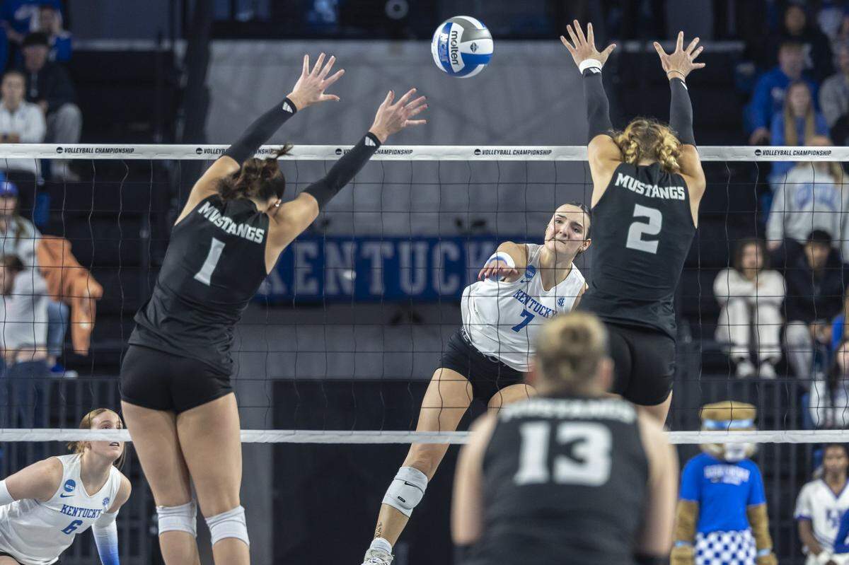 Kentucky Wildcats outside hitter Eva Hudson (7) hits the ball as Cal Poly Mustangs outside hitter Emma Fredrick (1) and Cal Poly Mustangs middle blocker Chloe Leluge (2) defend during the 2025 NCAA Volleyball Tournament Sweet 16 Lexington Regional at Historic Memorial Coliseum in Lexington, Ky., on Thursday, Dec. 11, 2025. Cal Poly’s season ended in a 3-0 sweep.