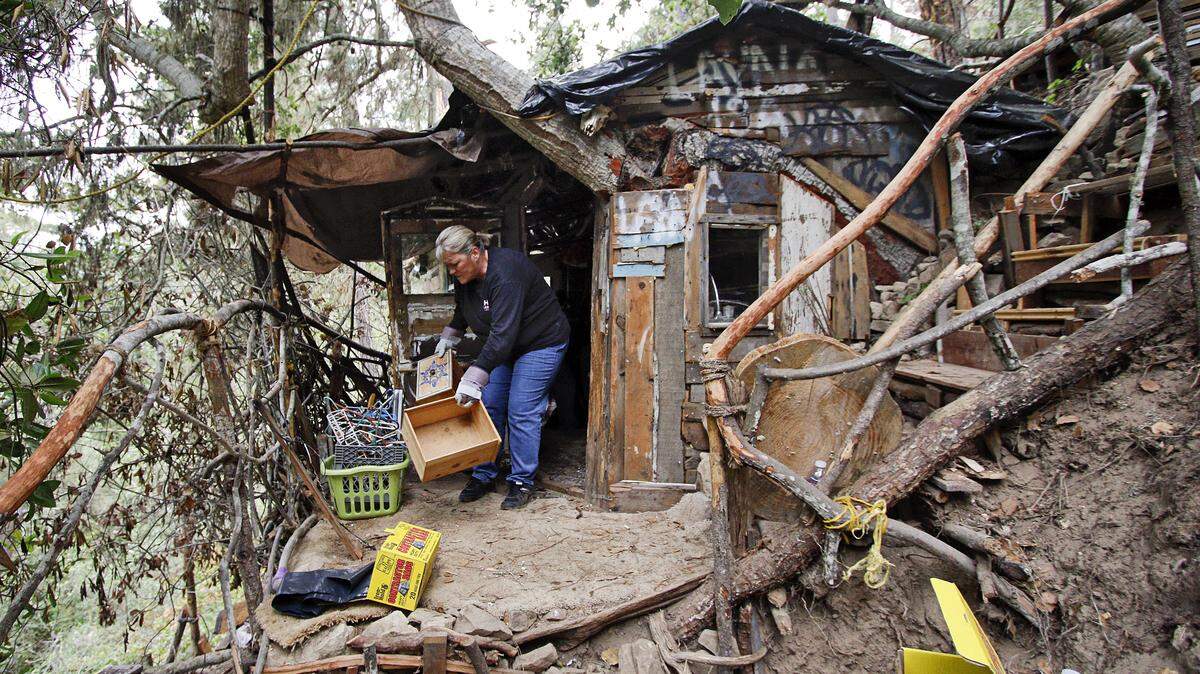 Juanita Poff helps clean out an illegal encampment recently discovered at the north end of Trenton Avenue in Cambria.
