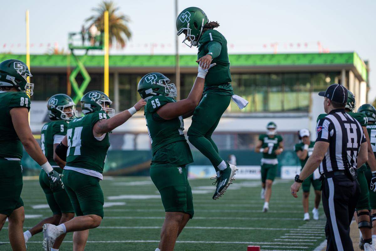 Cal Poly offensive lineman Tristan Fui lifts quarterback Anthony Grigsby into the air in celebration after Grigsy scored a touchdown in the first half against Western Oregon on Saturday, Sept. 13, 2025. The Mustangs defeated the Wolves in a 56-7 rout at home.