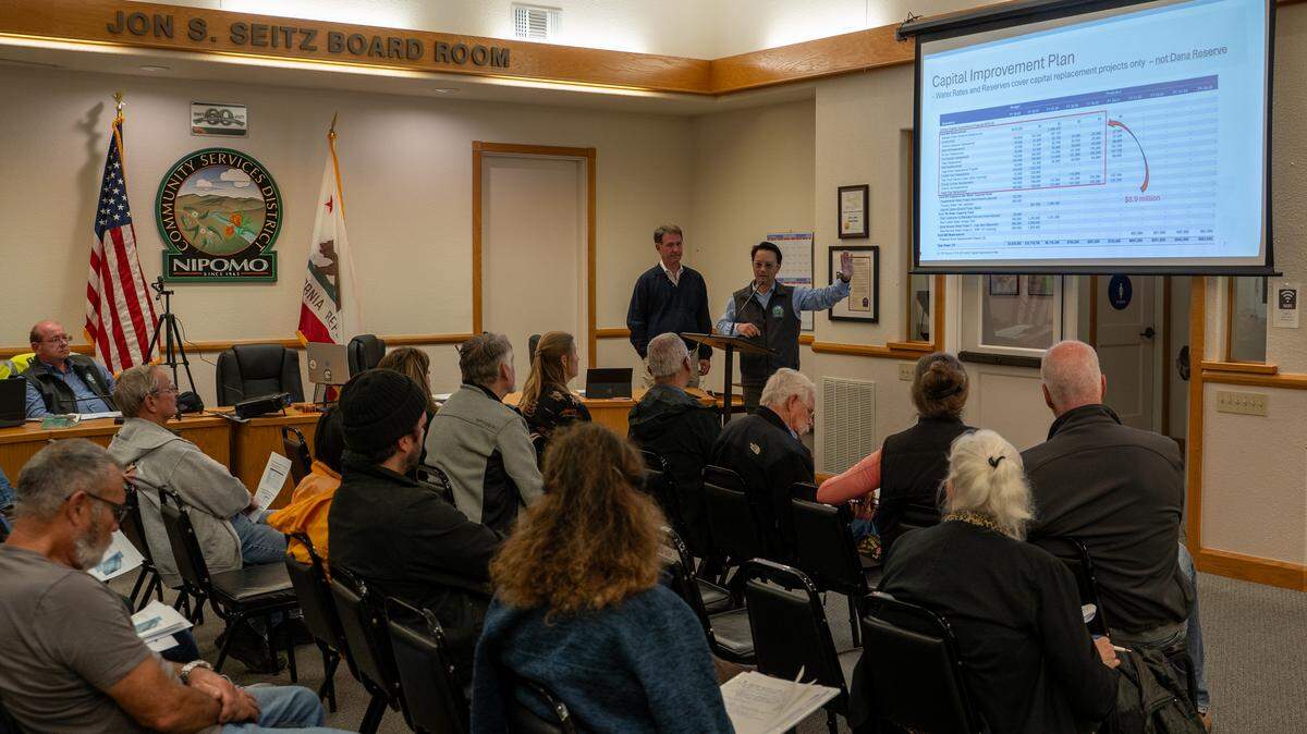 Consultant Clayton Tuckfield and Nipomo Community Services District general manager Ray Dienzo speak to a group of Nipomo residents at a town hall meeting on raising water rates on Thursday, Nov. 13, 2025. Average rate payers could see their water bill rise by 9.8% each year through