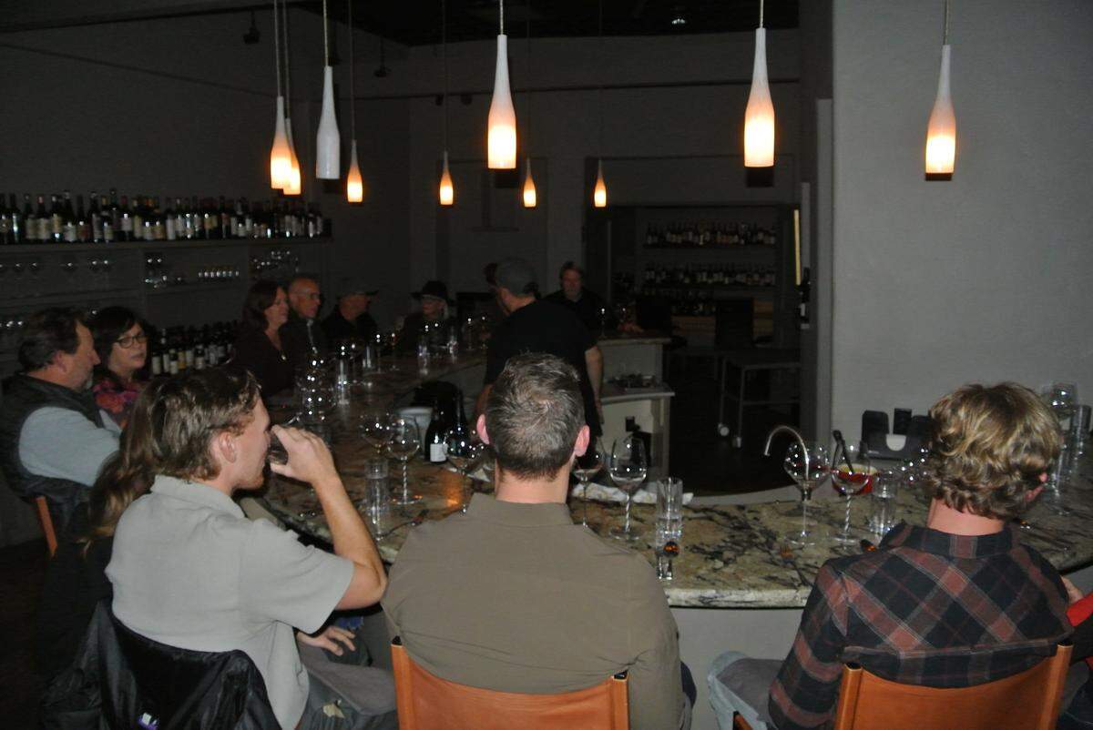 Diners at Paso Robles’ Somm’s Kitchen sit at a circular bar in anticipation of an eight-course meal with 16 local and international wine pairings on Dec. 10, 2024.