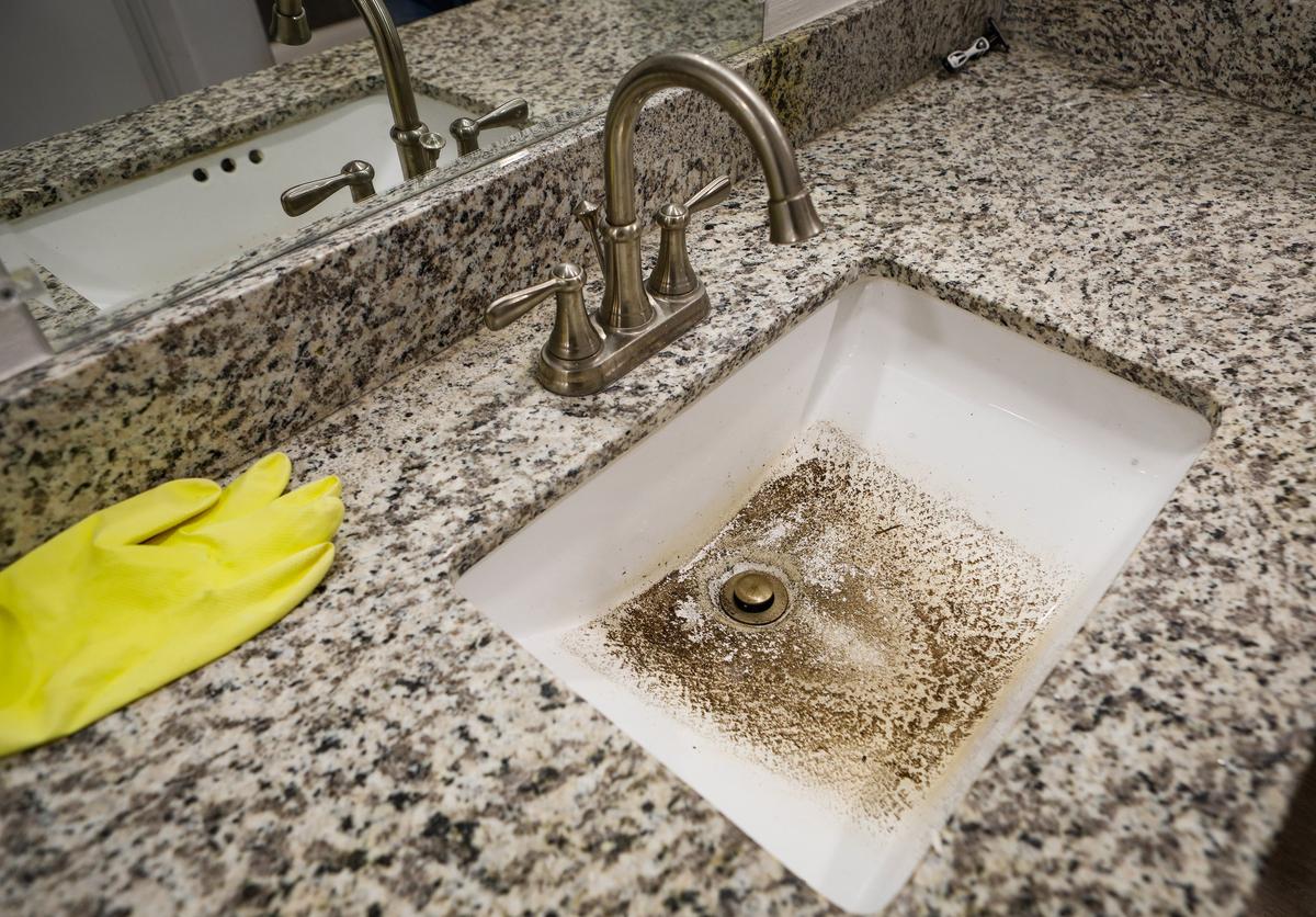 Dirt sits in a sink after dirty water came up into the sink from the drain, a common occurrence inside of a college student’s apartment at The SLO Student Living complex near Cal Poly in San Luis Obispo.