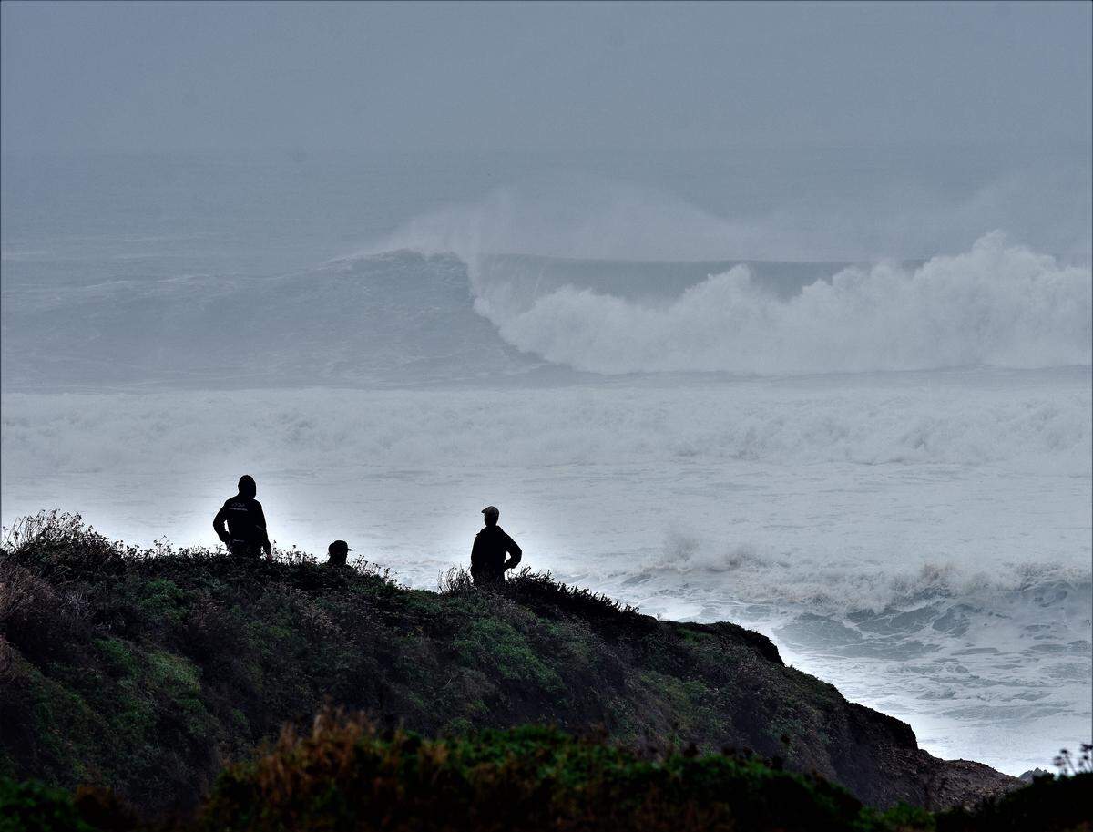Surfers surveying the high waves on a stormy Thursday morning at Montaña de Oro State Park.