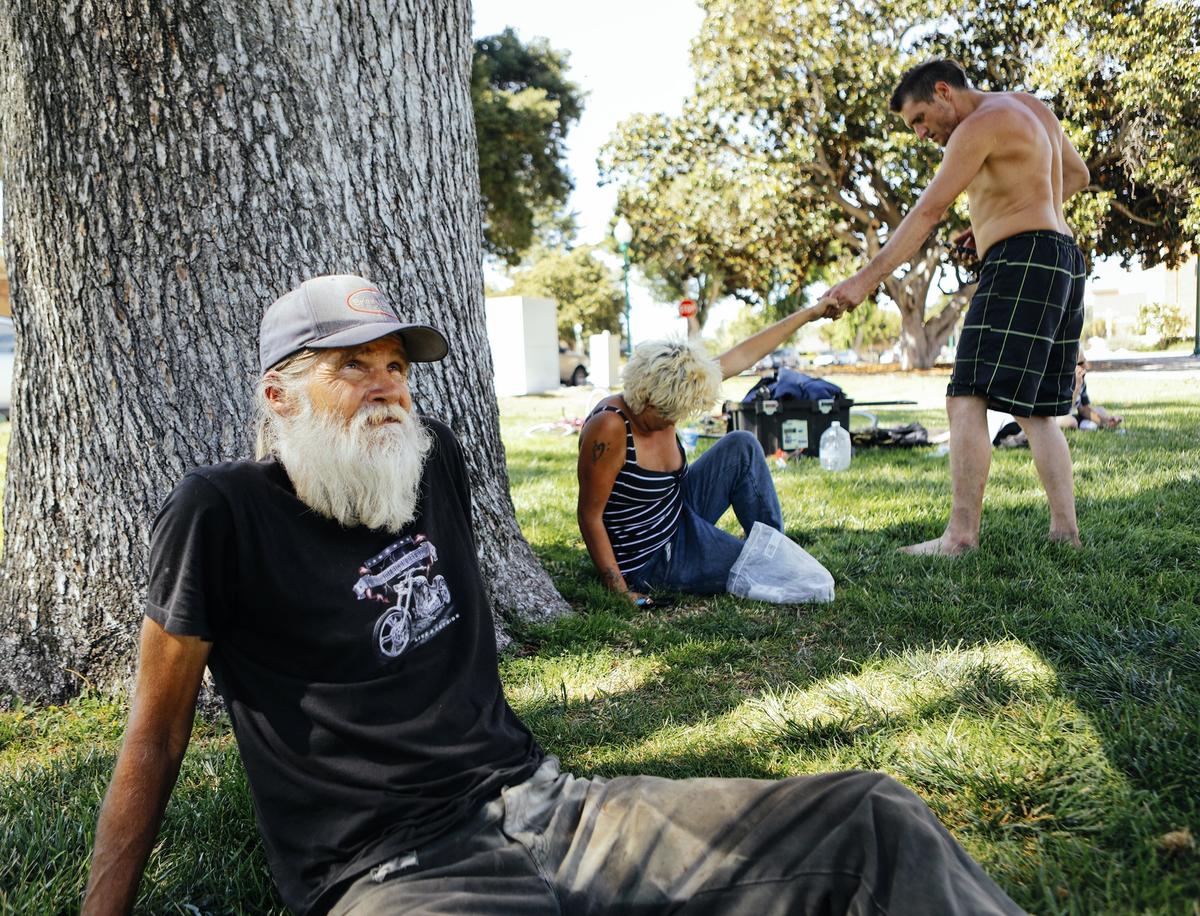 Rick Hurd, left, Makaila Currell and her fiance, Carey Vasquez, rest in the shade of a tree at the Sunken Gardens park in Atascadero in July.