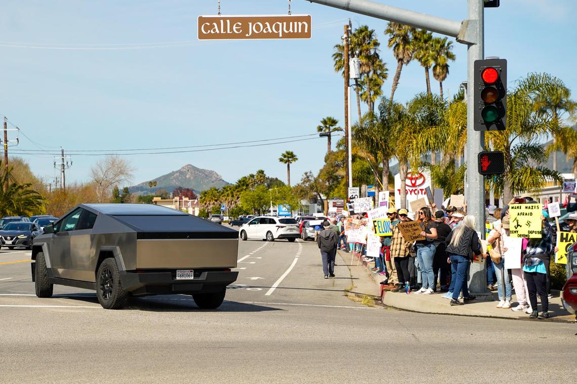 A Tesla Cybertruck passes demonstrators protesting Elon Musk’s new role in the federal government on Monday, Feb. 17, 2025. Around 500 people turned out to protest Musk and President Donald Trump’s first month of policies.