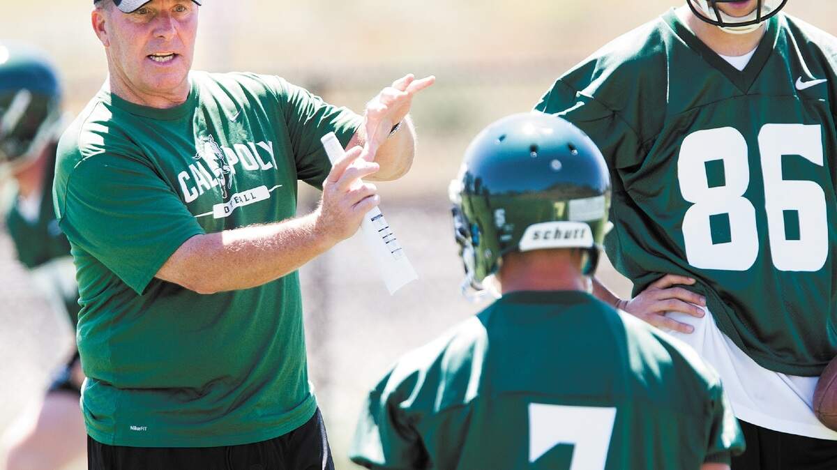Cal Poly head coach Tim Walsh, left, details a play during practice Monday. Walsh has compiled a 11-11 record in two years at Cal Poly.