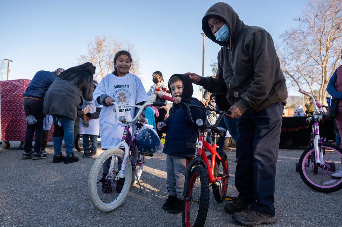 Seven-year-old Sophia Arreola, left, and her 3-year-old brother, Christian, with the new bikes they got during the San Luis Obispo County Sheriff’s Office bicycle giveaway on Dec. 13, 2022.