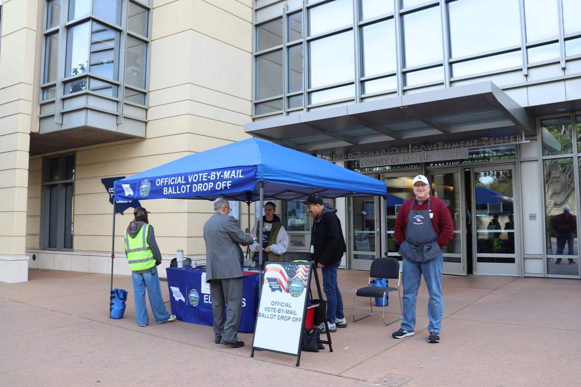 Volunteers were set up outside the San Luis Obispo County government building on Election Day, Nov. 4, 2025, picking up ballots from the passenger windows of cars driving by to drop off their votes.