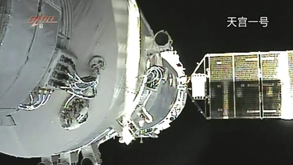 In this June 13, 2013, file image released by China's Xinhua News Agency, the Shenzhou-10 manned spacecraft is seen while conducting docking with the orbiting Tiangong-1 space module. China’s defunct Tiangong-1 space station is expected to re-enter Earth’s atmosphere sometime in the coming days, although the risk to people and property on the ground is considered low.