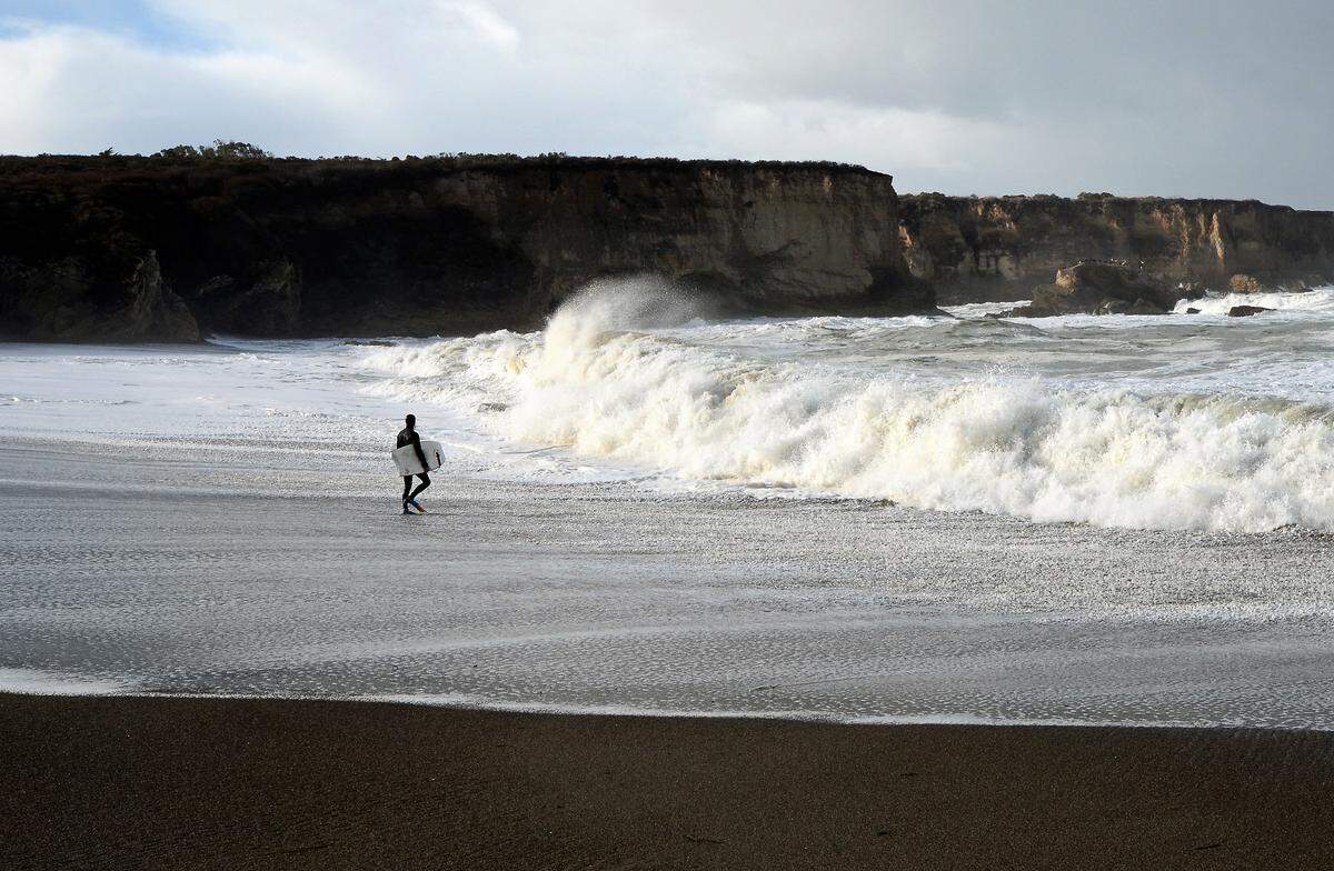 A surfer surveys the waves at Montana de Oro in San Luis Obispo County, California.