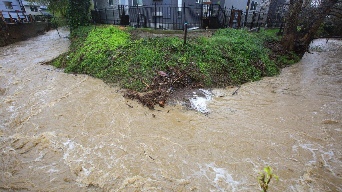 San Luis Obispo Creek takes a hard right angle turn near Dana Street in San Luis Obispo, running brown with mud during an atmospheric river storm on March 14, 2023.