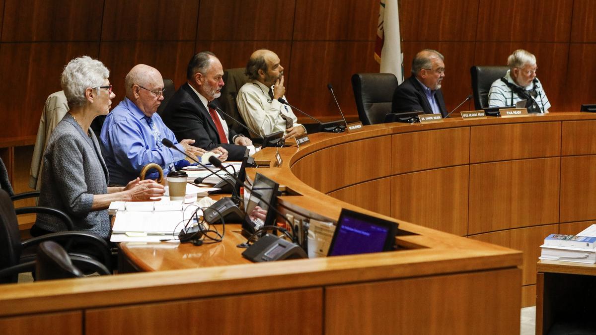 The San Luis Obispo County Air Pollution Control District Hearing Board listens to details of the settlement Monday in the Board of Supervisors Chambers.