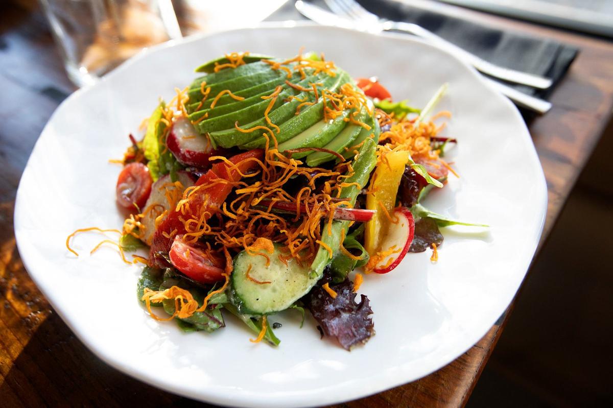 Kiko’s Creek Salad is made with mixed greens, cucumber, radish, cherry tomato, roasted peppers, sweet potato crisp and topped with a chile guero-dijon vinaigrette.