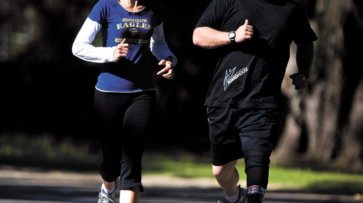 Author Wendelin Van Draanen, left, runs with Dana Cummings, executive director of AmpSurf, in Pismo Beach. Cummings was one of the amputee athletes that Van Draaned consulted while writing her book "The Running Dream."