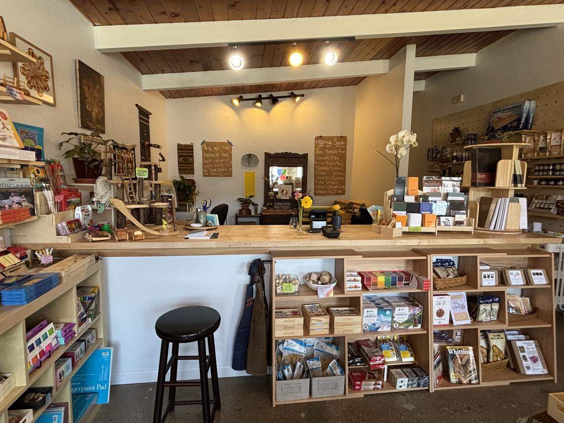 The wooden black stool awaits the next guest of Estero Bay Art + Craft, near whittling kits, watercolor sets and kids toys.