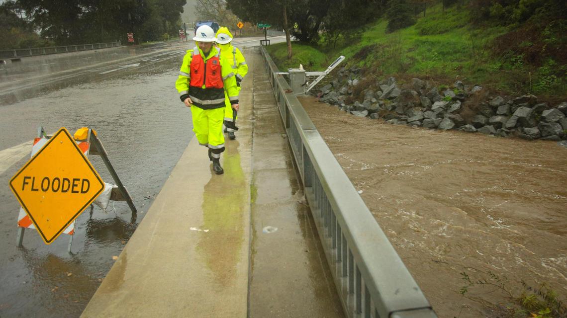 Cory Burt and Lauren Gautchi with San Luis Obispo County Public Works inspect flood monitoring equipment on the Marsh Street bridge over San Luis Obispo Creek on Feb. 13, 2025.