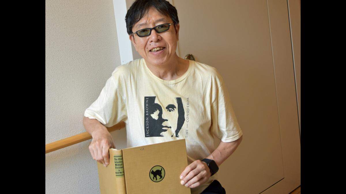 Japanese historian Yuki Kimura holds a copy of the book in which he found a 1945 letter that Edward “Eddie” Borradori of Cayucos wrote to his parents. The initials E.B. are seen at the top of the book’s cover.