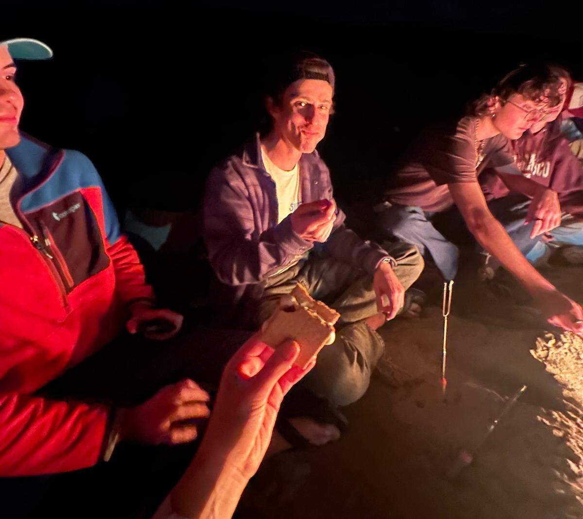 Kenneth Taylor enjoys a campfire with friends. Taylor, a third-year Cal Poly student, died while on a climbing trip at Salmon Creek waterfall in Big Sur on April 6, 2024.