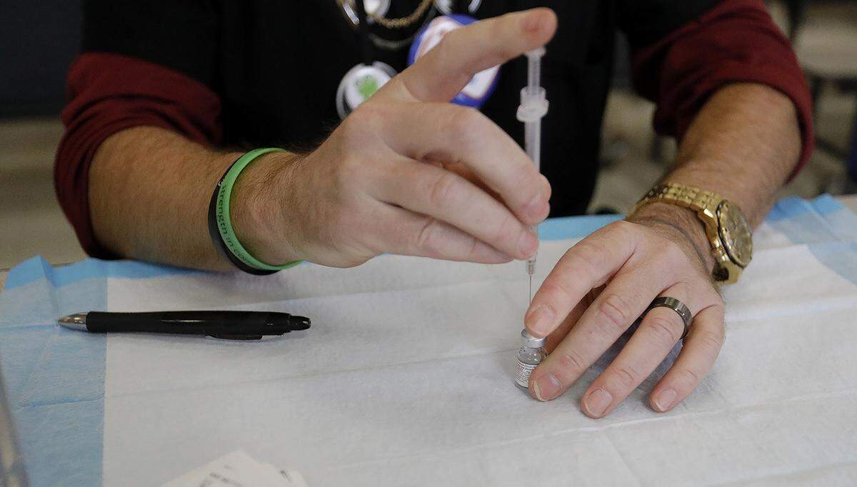San Luis County Health Department Psych Tech John “Mike” Jamison readies COVID-19 vaccination syringes. The health department conducted a pop-up vaccination clinic at Santa Rosa Academic Academy in Atascadero, Friday, Nov. 3, 2022.