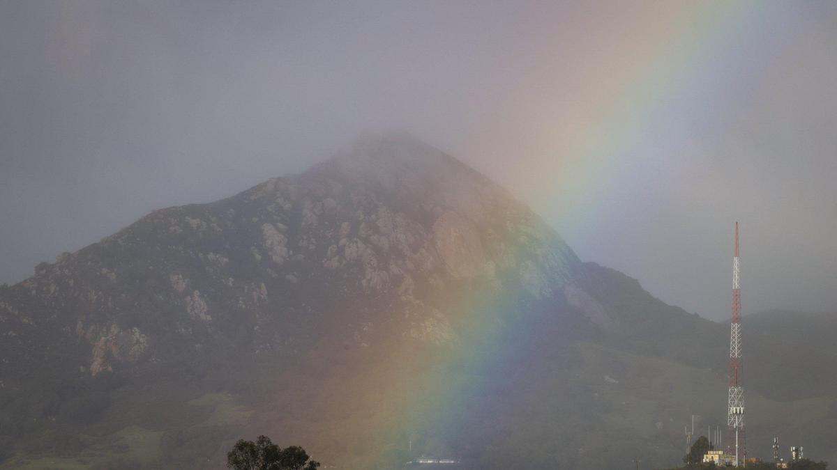 A rainbow lands near Bishop Peak as seen from Cal Poly. Storm updates Jan 16, 2023, as a series of atmospheric river storms hit the coast.