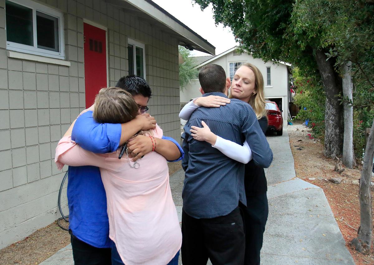 Friends console Riley Manford, 27, and, Nick Regalia, 33, after their dog was shot and killed by a San Luis Obispo police officer outside their rental home in the 600 block of Santa Rosa Street.